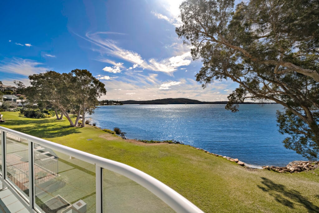 Balcony view of lake and lawn area beside Woody’s Place on the waterfront