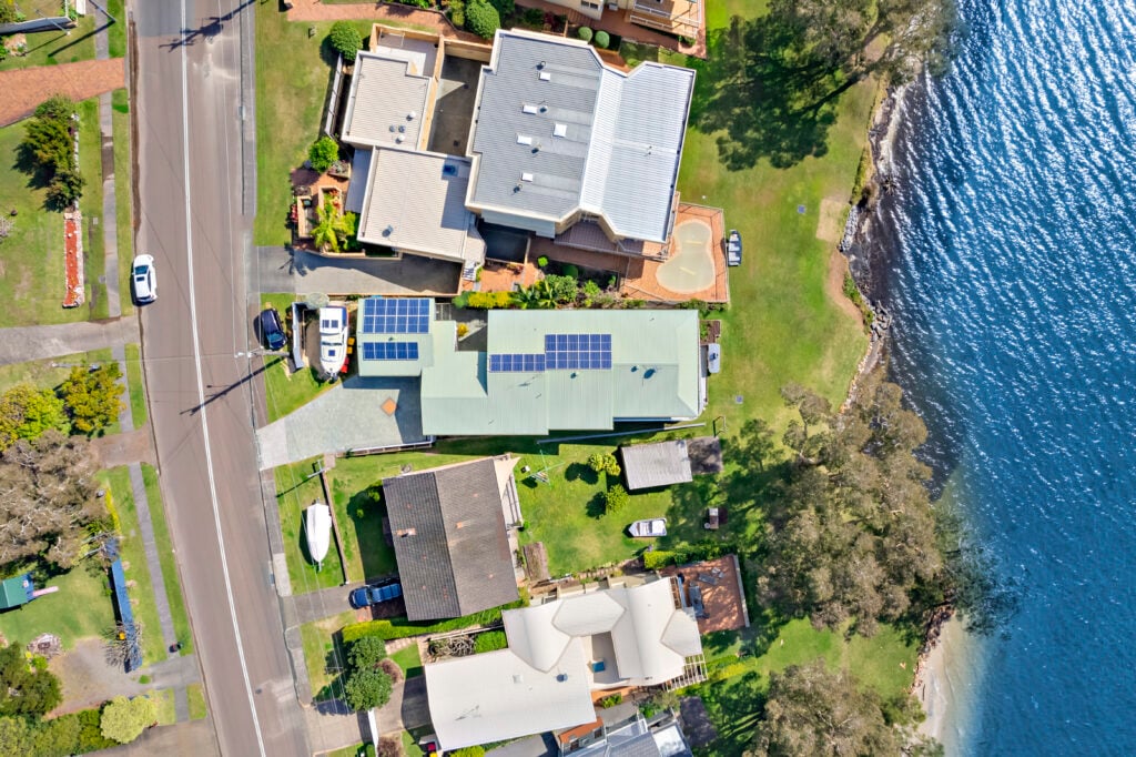 Aerial top-down view of Woody’s Place, neighbouring homes, road and foreshore along Soldiers Point waterfront